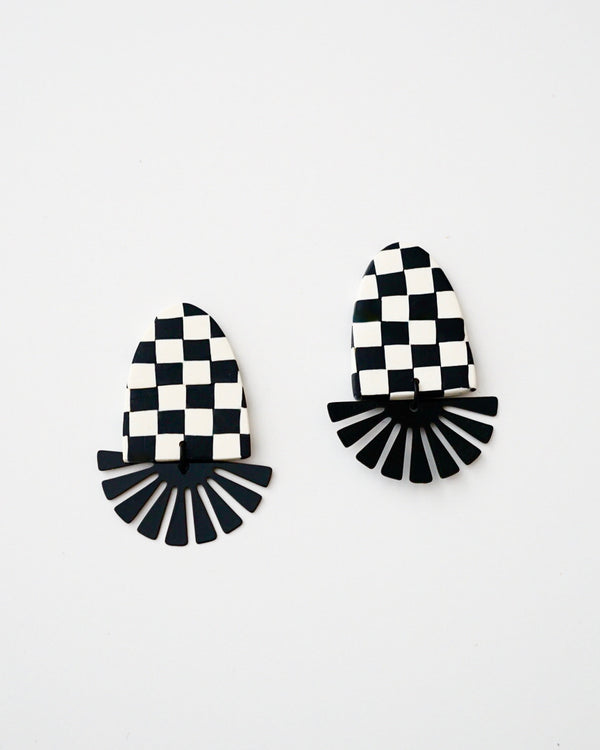 Handmade Checker Polymer Clay Statement Earrings with Titanium Posts  Cute and trendy clay dangles in black & white checker pattern. Black painted brass geometric fan charms complete these modern clay earrings. Available with hypoallergenic titanium posts.