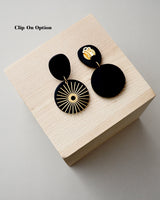 Handmade Brass & Black Polymer Clay Statement Earrings. Modern clay dangles with brass sunburst charms. Available with hypoallergenic titanium posts or clip-on option. These are stylish, lightweight and will be a standout for a chic daytime look or a night out.