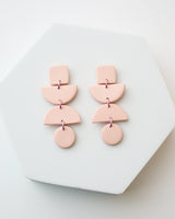 Handmade Pale Pink Polymer Clay Statement Earrings. These modern and geometric clay dangles bring movement and style to your day or evening. Hypoallergenic titanium posts or stainless steel clip-on.