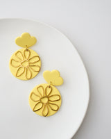 Handmade Polymer Clay Statement Earrings with Brass Daisy Charms.  Modern pastel clay dangles that are bold and stylish but lightweight. Hypoallergenic titanium posts and backs; ideal for sensitive ears. Available in pierced or clip-on options. Colors sunshine yellow, pastel blue, ivory and moss green.