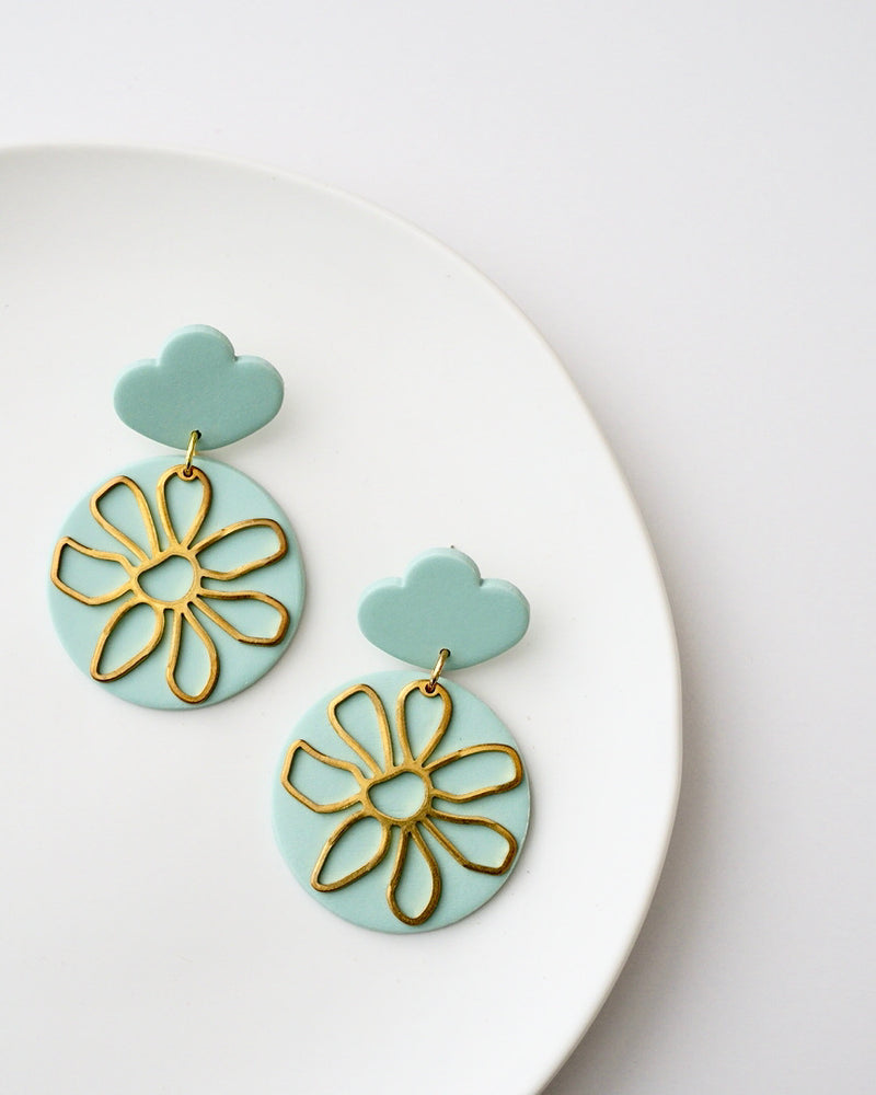 Handmade Polymer Clay Statement Earrings with Brass Daisy Charms.  Modern pastel clay dangles that are bold and stylish but lightweight. Hypoallergenic titanium posts and backs; ideal for sensitive ears. Available in pierced or clip-on options. Colors sunshine yellow, pastel blue, ivory and moss green.