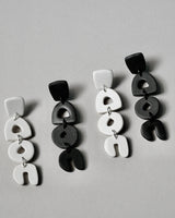 Handmade Abstract White Polymer Clay Statement Earrings with Titanium Posts.  Dainty but unique, these clay dangles feature abstract shapes in a minimal design. Undoubtedly stylish and lightweight to wear all day, everyday. Hypoallergenic titanium earring posts.