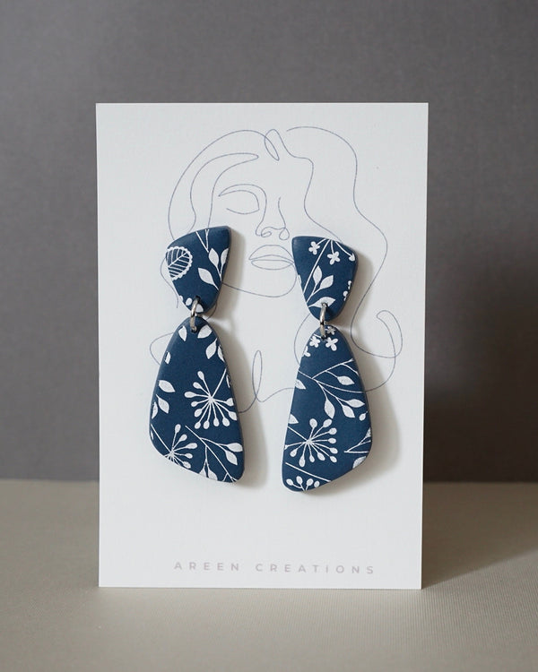 Handmade Blue & White Floral Print Polymer Clay Statement Earrings.  Modern and cute denim blue clay dangles with detailed white floral print. Available with hypoallergenic titanium posts or clip-on option. These are stylish, lightweight and will be a standout for a chic daytime look or a night out. These earrings are a part of the Botanical Polymer Clay Collection.