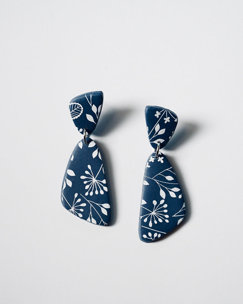 Handmade Blue & White Floral Print Polymer Clay Statement Earrings.  Modern and cute denim blue clay dangles with detailed white floral print. Available with hypoallergenic titanium posts or clip-on option. These are stylish, lightweight and will be a standout for a chic daytime look or a night out. These earrings are a part of the Botanical Polymer Clay Collection.
